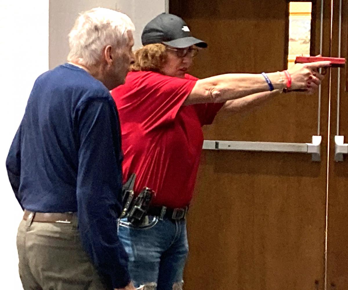 Angela Armstrong (right) of the Buckeye Firearms Association provides small-firearms training to Gary Beck (left) of Stryker during an active shooter drill in the Protecting Houses of Worship training workshop at the Church of Christ at West Unity on April 4, 2026.